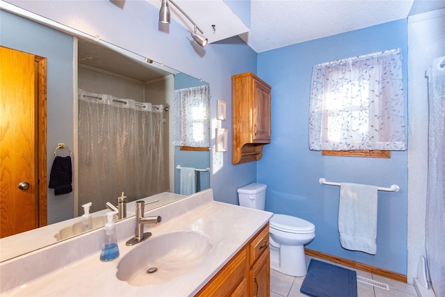 bathroom with a textured ceiling, toilet, vanity, and tile patterned flooring