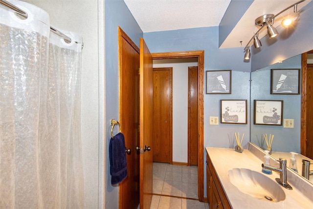 bathroom featuring vanity, tile patterned floors, and a textured ceiling