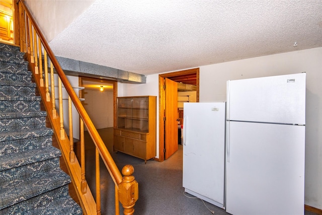 kitchen with a textured ceiling and white refrigerator