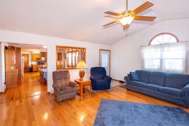 living room with ceiling fan, lofted ceiling, and light wood-type flooring