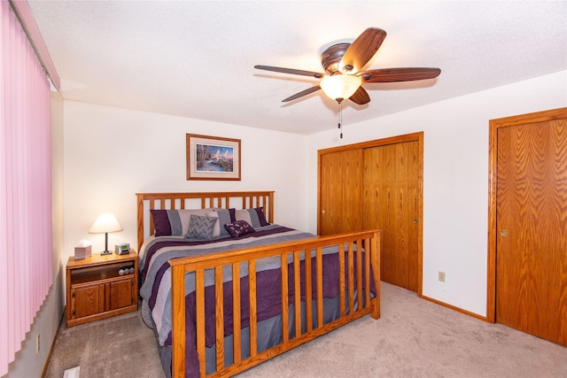 carpeted bedroom featuring ceiling fan and a textured ceiling