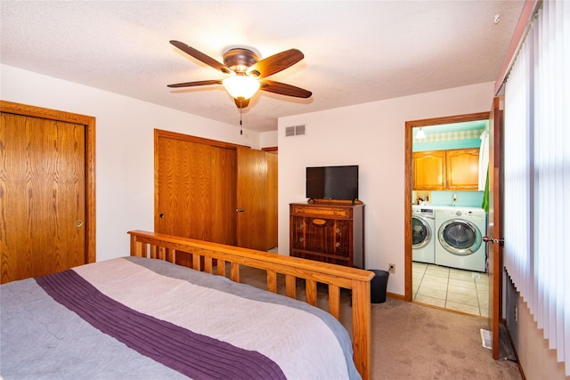 bedroom featuring ceiling fan, light carpet, and washing machine and dryer