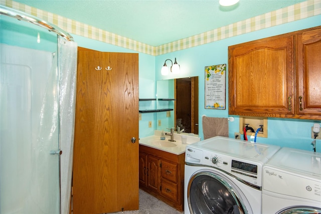 clothes washing area with independent washer and dryer and sink