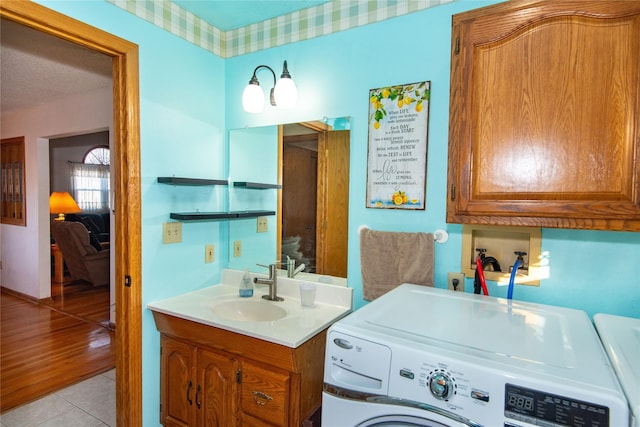 bathroom featuring a textured ceiling, vanity, washing machine and dryer, and tile patterned flooring