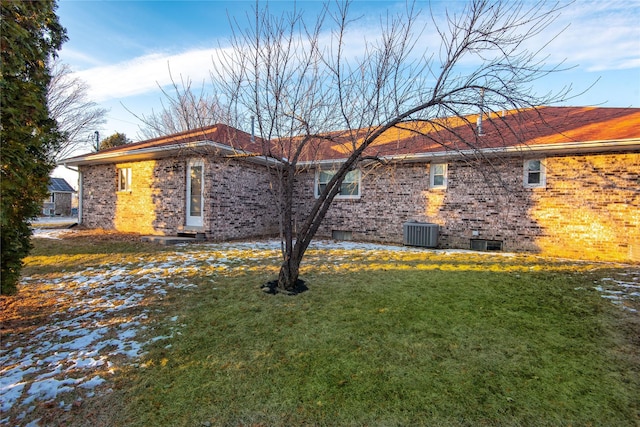 view of property exterior with central AC unit and a yard