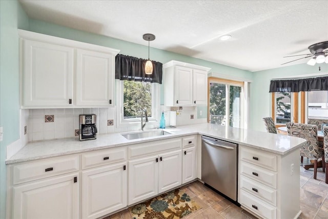 kitchen with white cabinetry, kitchen peninsula, decorative light fixtures, dishwasher, and sink