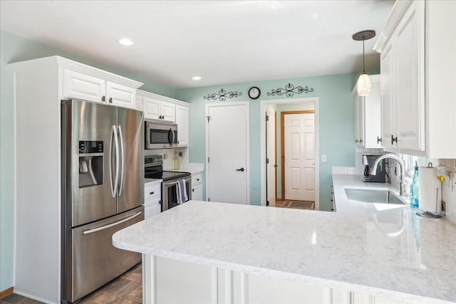 kitchen with sink, white cabinets, appliances with stainless steel finishes, and kitchen peninsula