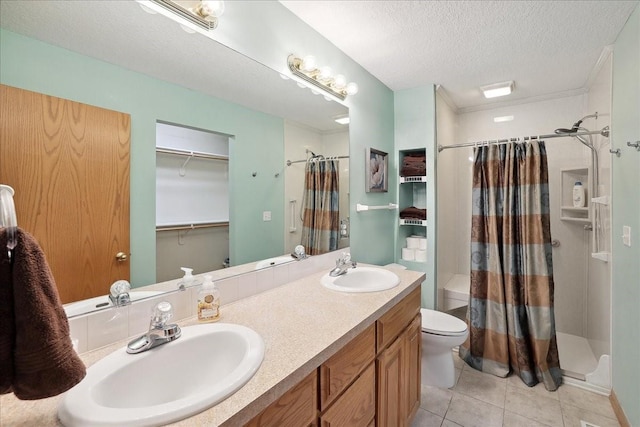 bathroom featuring toilet, tile patterned flooring, a textured ceiling, crown molding, and vanity