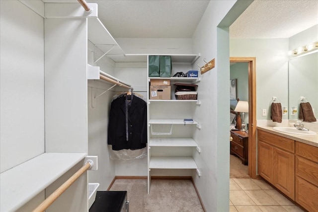 walk in closet with sink and light tile patterned floors