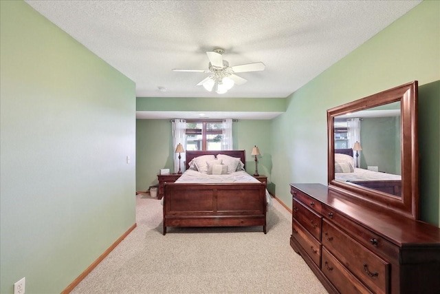 carpeted bedroom featuring ceiling fan and a textured ceiling