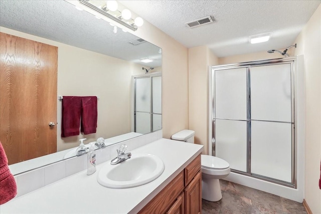 bathroom with a textured ceiling, toilet, a shower with door, and vanity