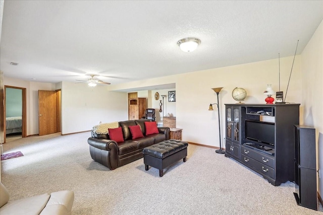 carpeted living room featuring a textured ceiling and ceiling fan