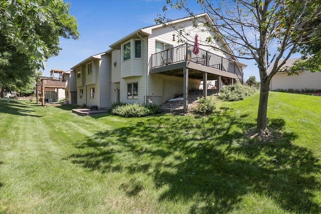 back of property featuring a wooden deck and a lawn