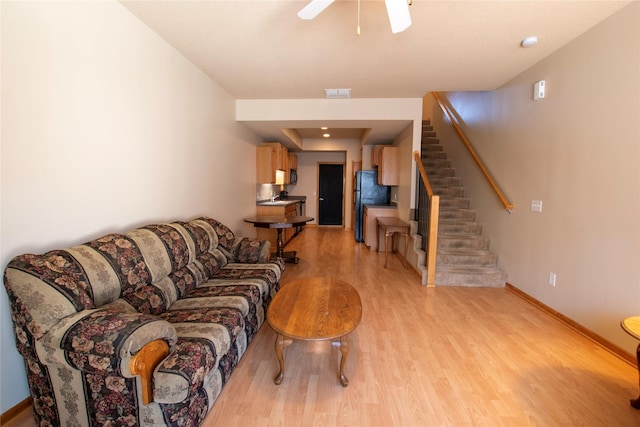 living room with ceiling fan and light wood-type flooring