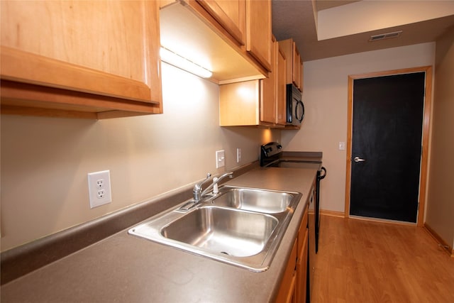 kitchen featuring sink, electric range oven, and light hardwood / wood-style flooring