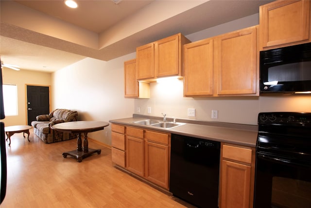 kitchen featuring black appliances, light brown cabinets, light hardwood / wood-style floors, sink, and ceiling fan