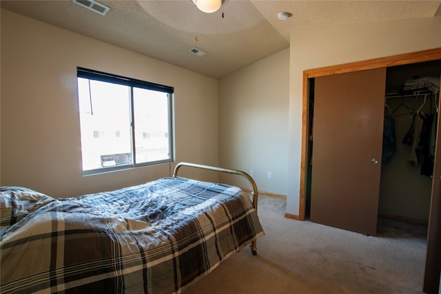 bedroom featuring light carpet, a closet, lofted ceiling, and ceiling fan