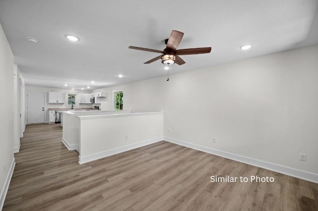 unfurnished living room with ceiling fan and hardwood / wood-style floors