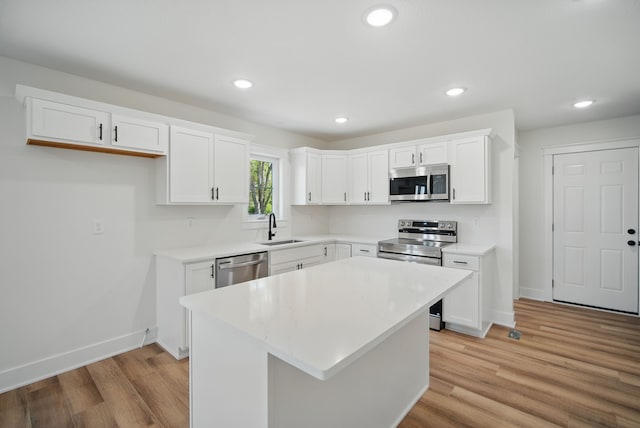 2527 Shaw St, Des Moines, IA 50317 - kitchen featuring appliances with stainless steel finishes, a sink, baseboards, white cabinets, and recessed lighting