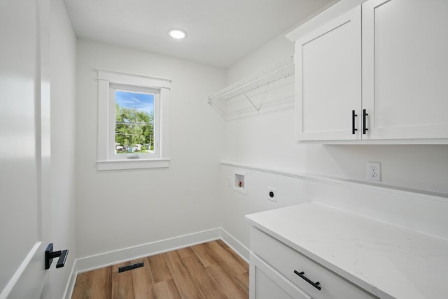 2527 Shaw St, Des Moines, IA 50317 - washroom with electric dryer hookup, hookup for a washing machine, cabinet space, light wood-style flooring, and baseboards