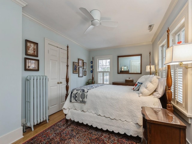 bedroom with ceiling fan, wood-type flooring, radiator heating unit, and ornamental molding