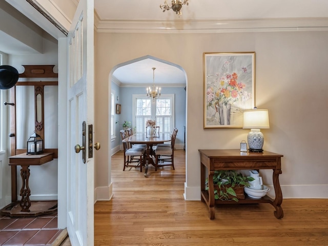 hall featuring ornamental molding, a chandelier, and hardwood / wood-style flooring