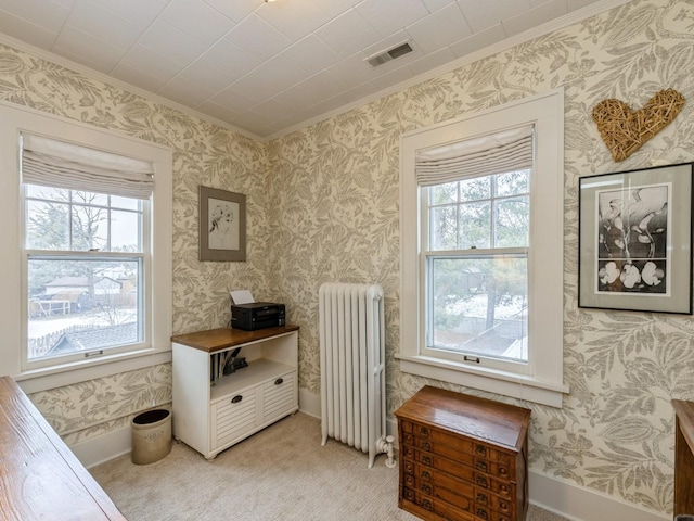 sitting room featuring light colored carpet, radiator heating unit, and ornamental molding