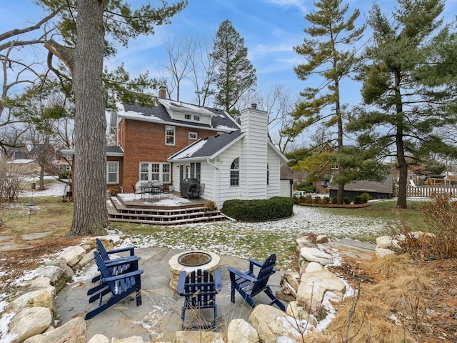 rear view of house featuring a deck and an outdoor fire pit