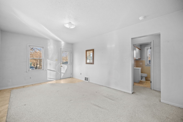 empty room featuring light tile patterned floors and a textured ceiling