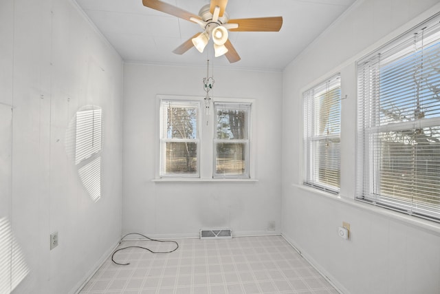 spare room with ceiling fan and crown molding