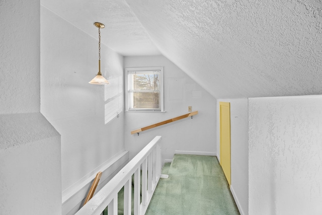 corridor featuring a textured ceiling, lofted ceiling, and carpet floors