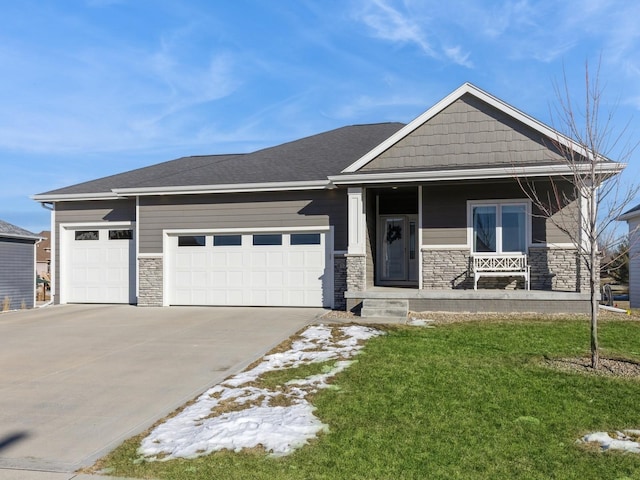 view of front facade featuring a garage, a front lawn, and covered porch