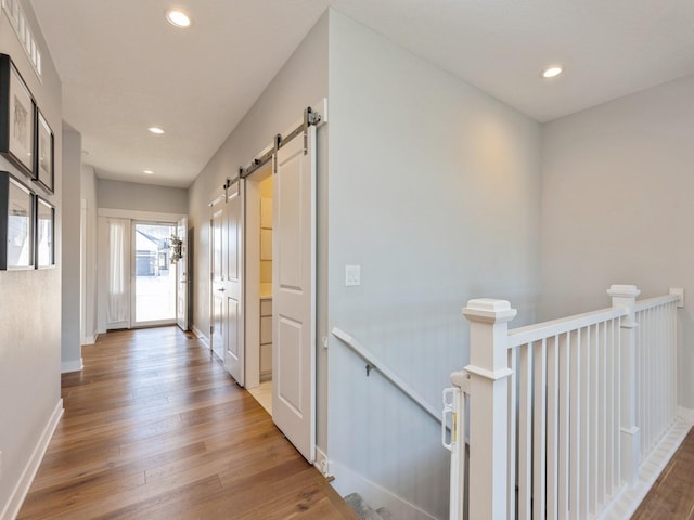 corridor featuring hardwood / wood-style floors and a barn door