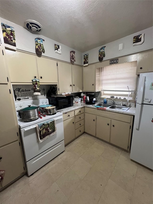 kitchen with sink, white appliances, a textured ceiling, and cream cabinetry