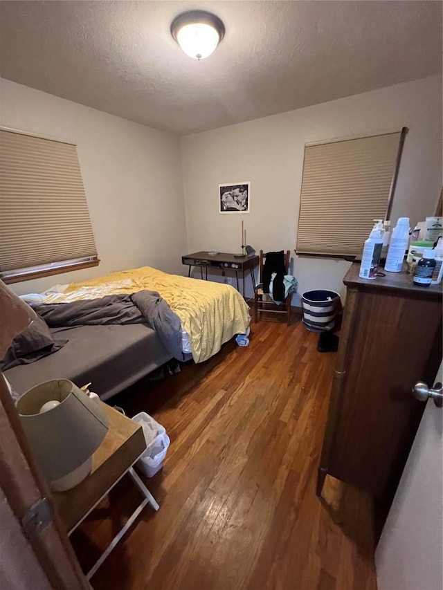 bedroom with a textured ceiling and hardwood / wood-style floors