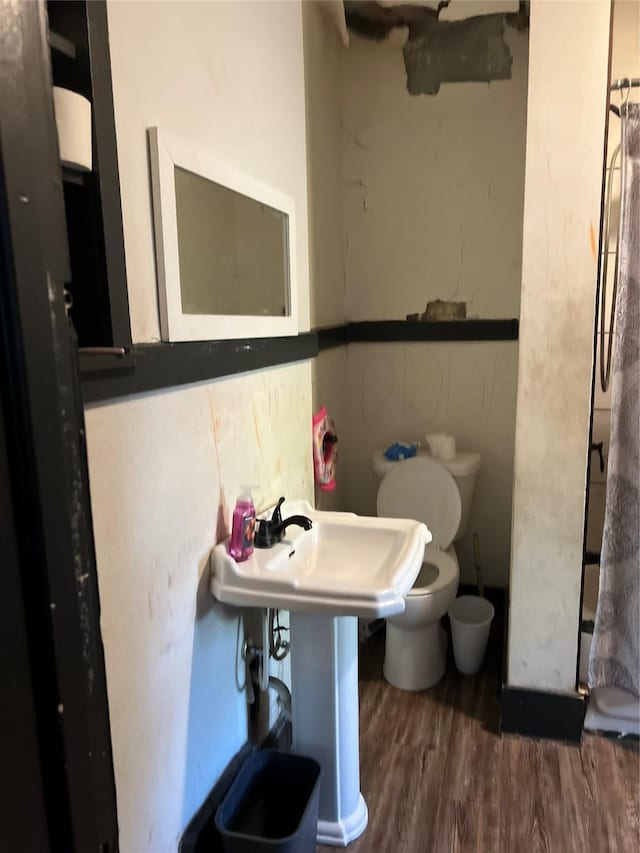 bathroom with toilet and hardwood / wood-style flooring