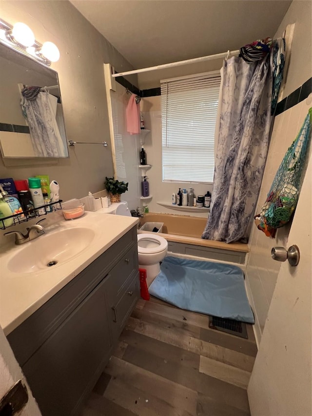 bathroom with toilet, vanity, and hardwood / wood-style flooring