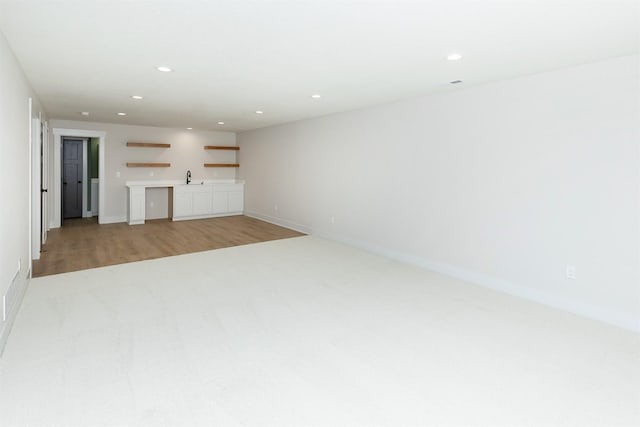 2390 Emma Ave, Des Moines, IA 50321 - unfurnished living room with wet bar, light carpet, recessed lighting, and light wood-type flooring