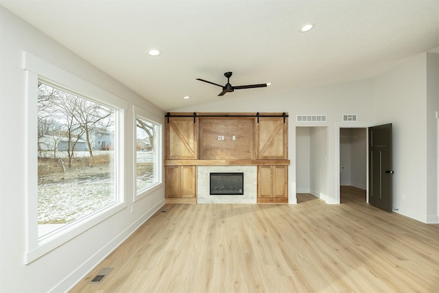 2390 Emma Ave, Des Moines, IA 50321 - unfurnished living room featuring lofted ceiling, light wood-style floors, a ceiling fan, recessed lighting, and a barn door