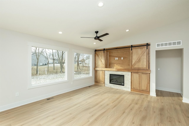 2390 Emma Ave, Des Moines, IA 50321 - unfurnished living room featuring plenty of natural light, a barn door, ceiling fan, recessed lighting, and vaulted ceiling