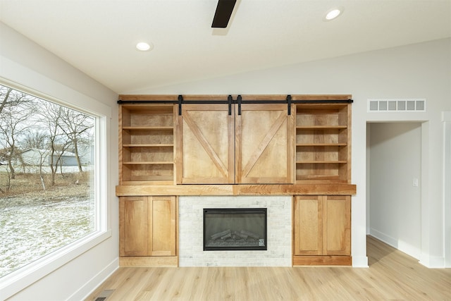 2390 Emma Ave, Des Moines, IA 50321 - unfurnished living room with light wood-style flooring, lofted ceiling, recessed lighting, a ceiling fan, and a glass covered fireplace