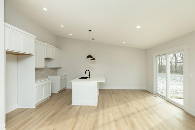 2390 Emma Ave, Des Moines, IA 50321 - kitchen with light wood-type flooring, decorative backsplash, recessed lighting, pendant lighting, and light countertops