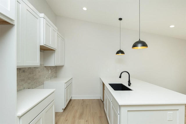 2390 Emma Ave, Des Moines, IA 50321 - kitchen featuring a peninsula, tasteful backsplash, light wood-style flooring, light countertops, and recessed lighting