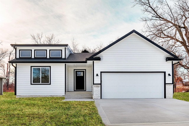 2390 Emma Ave, Des Moines, IA 50321 - view of front of property with concrete driveway, a garage, and a front lawn