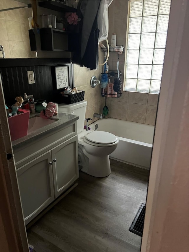 full bathroom featuring toilet, bathing tub / shower combination, wood-type flooring, and vanity