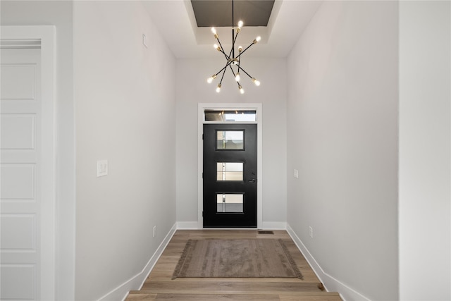 foyer entrance with a chandelier and wood-type flooring