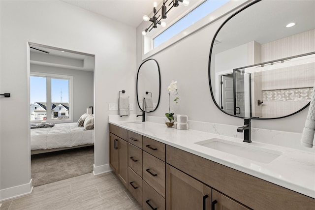 bathroom with an inviting chandelier, a shower with shower door, and vanity