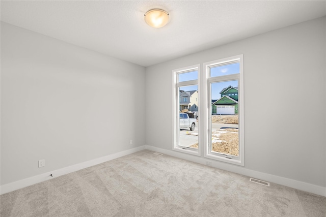 unfurnished room featuring light colored carpet