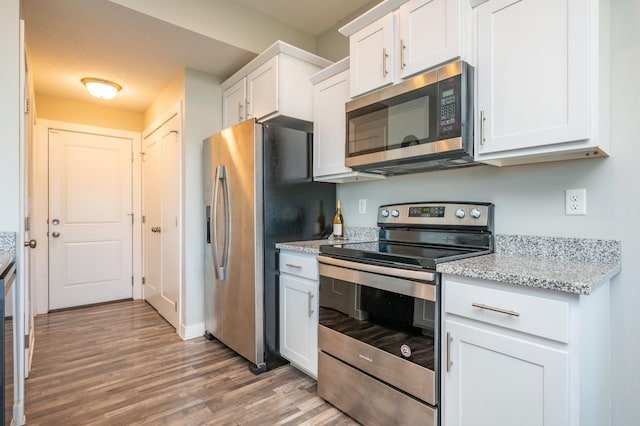 kitchen featuring light stone counters, light hardwood / wood-style floors, white cabinetry, and appliances with stainless steel finishes