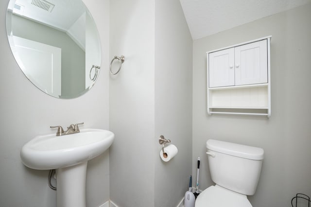 bathroom featuring a textured ceiling and toilet